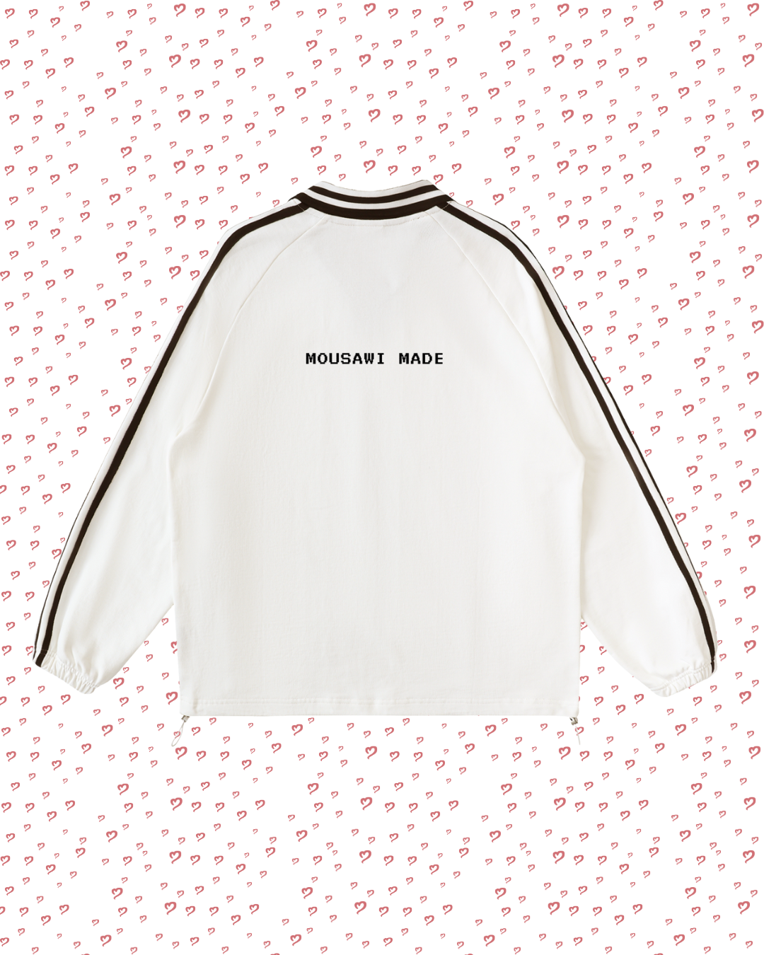 White sweatshirt with black trim on a pink background with heart patterns