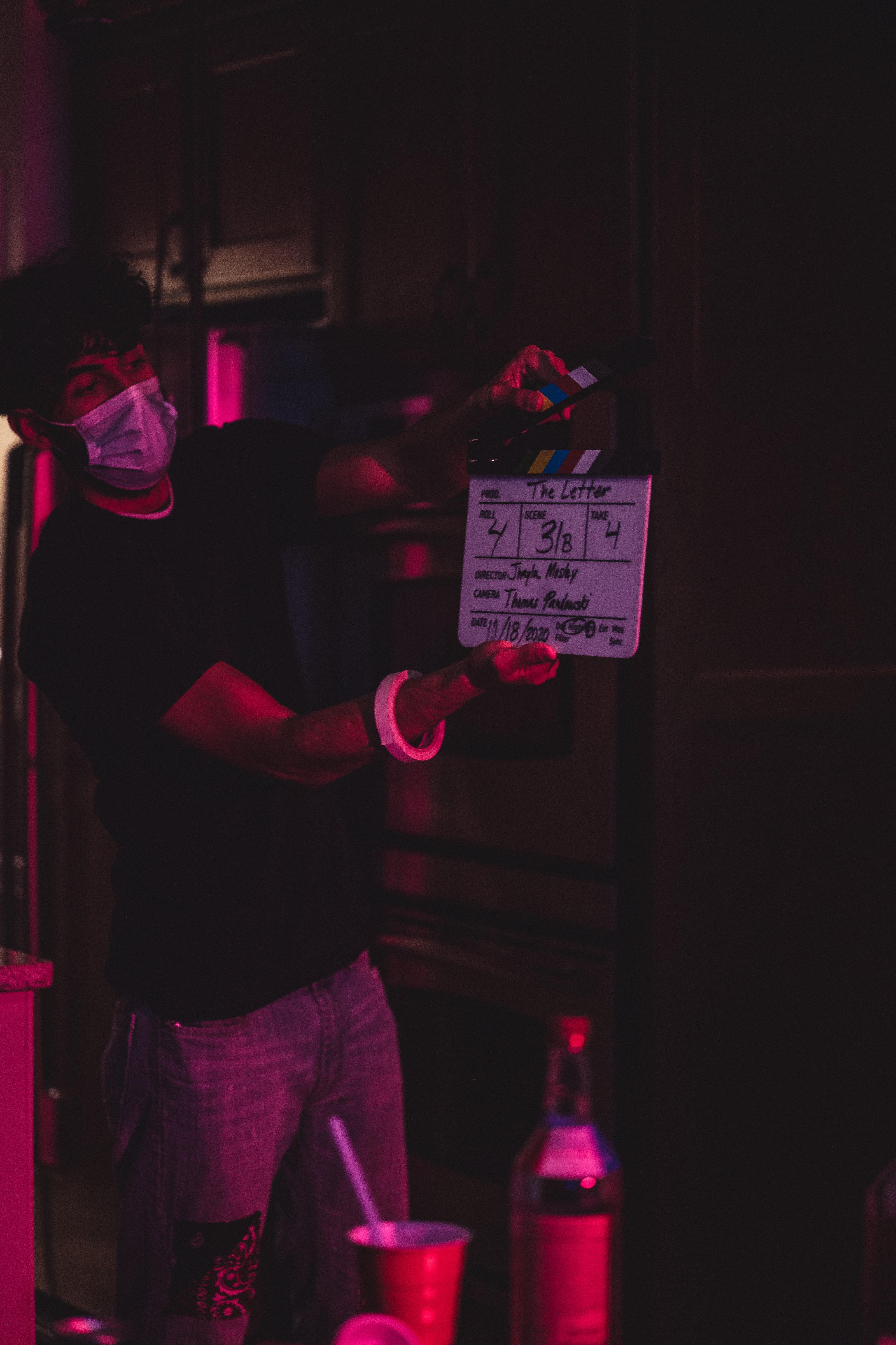 Mousawi on a film set holding a clapperboard during production