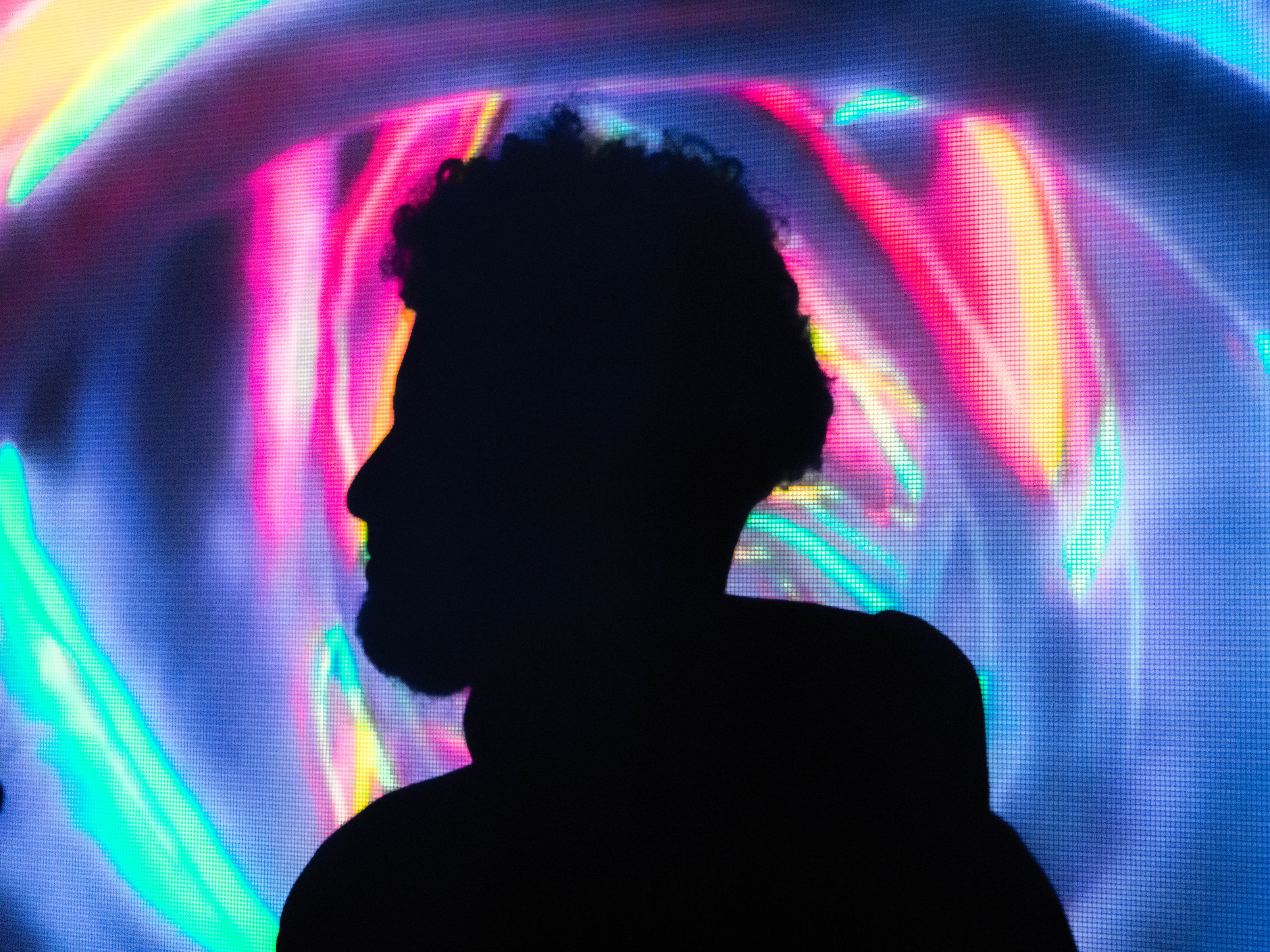 Silhouette portrait in front of neon light projection background