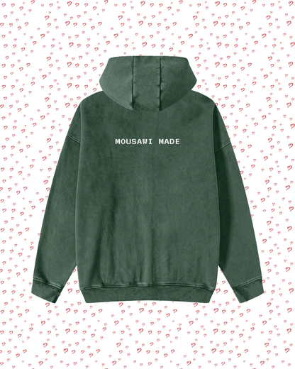 Green hoodie with 'MOUSAWI MADE' text on a white background with red heart patterns