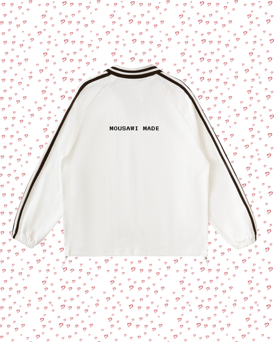 White sweatshirt with black trim on a pink background with heart patterns